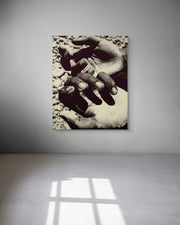 Metal print of hands holding a heart on a gray wall.