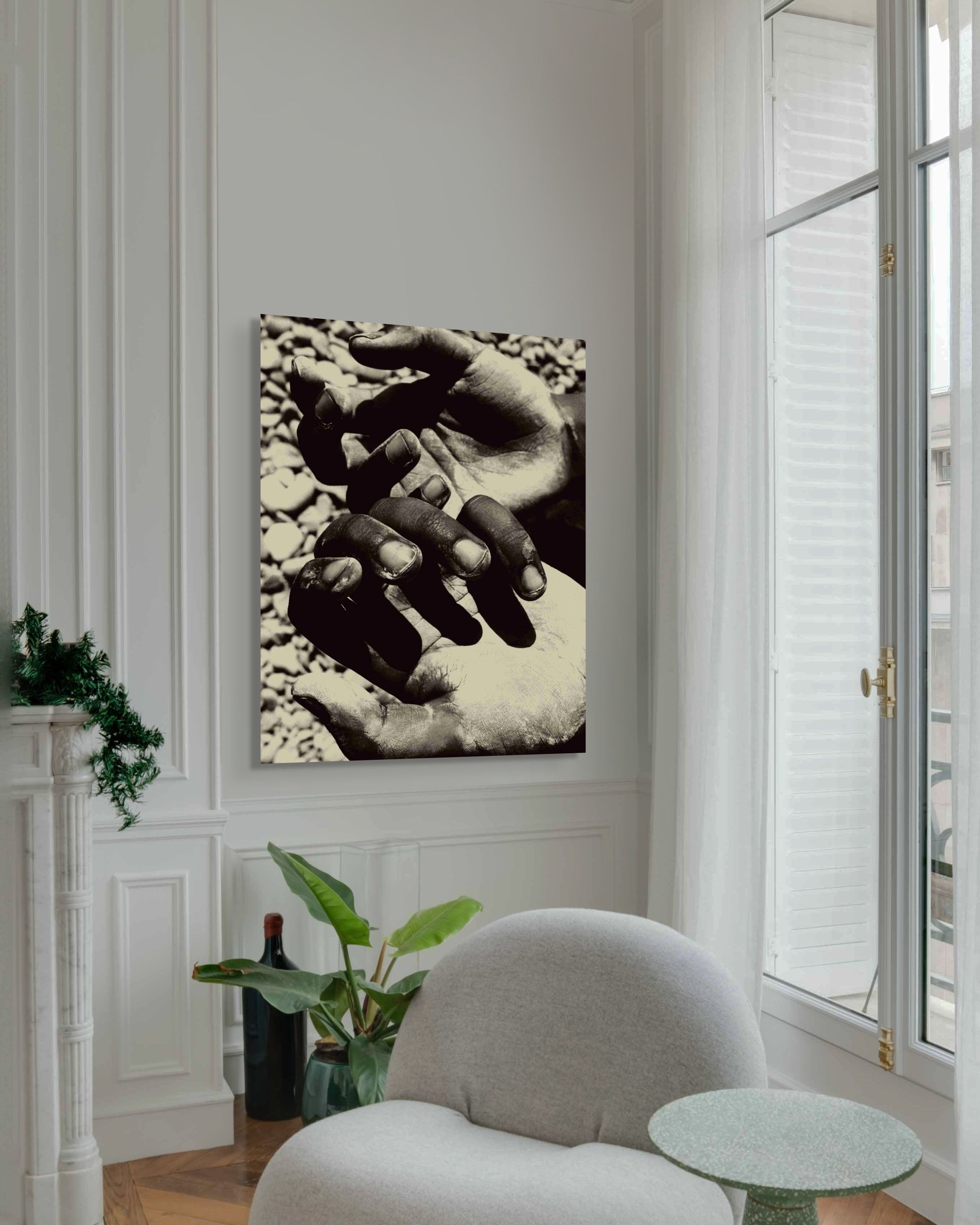 Metal wall art of hands on a wall in a room with a chair and plants. 