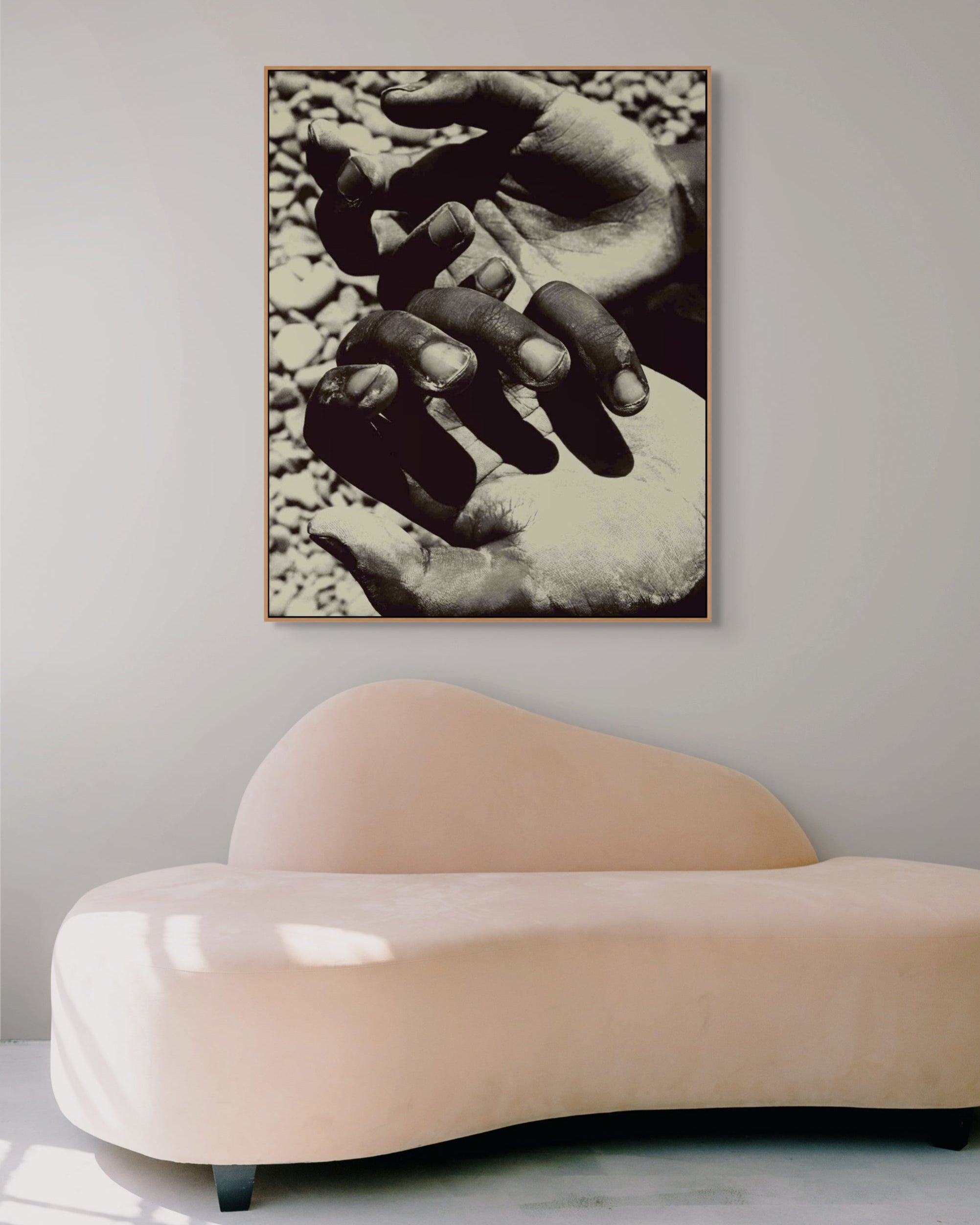 Framed fine art photograph Hands by Jonė Reed, displayed in minimalist interior with modern sofa