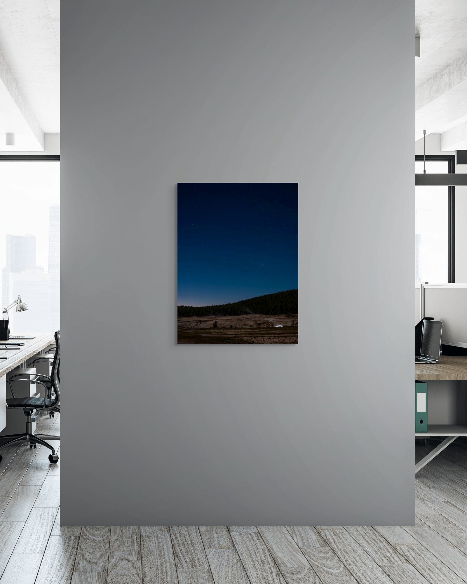 Metal print of a landscape hanging on a gray wall in an office setting.