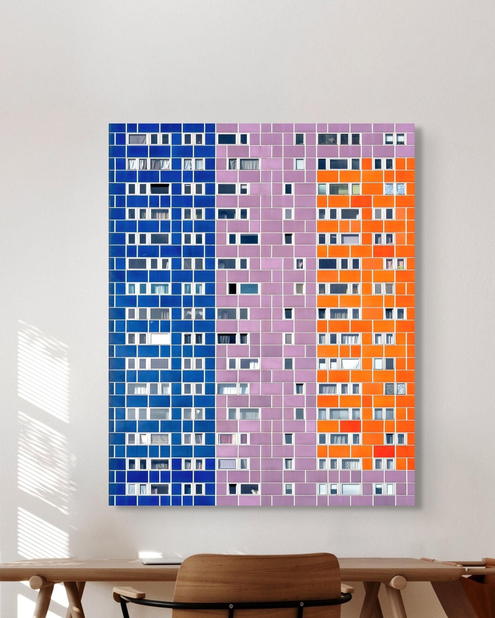 Colorful abstract wall art on a white wall with a wooden chair in the foreground.