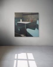 Framed photograph of a diner interior with a table and booths on a gray wall.