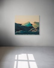 Metal print of a mountain landscape on a white wall.