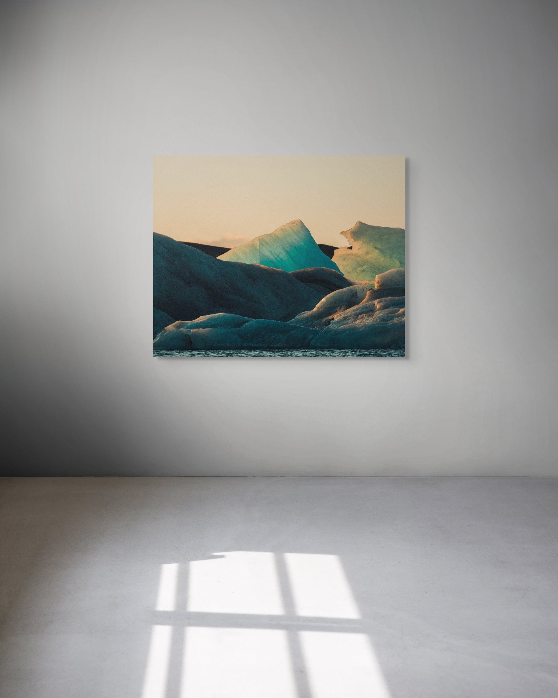 Metal print of a mountain landscape on a white wall.