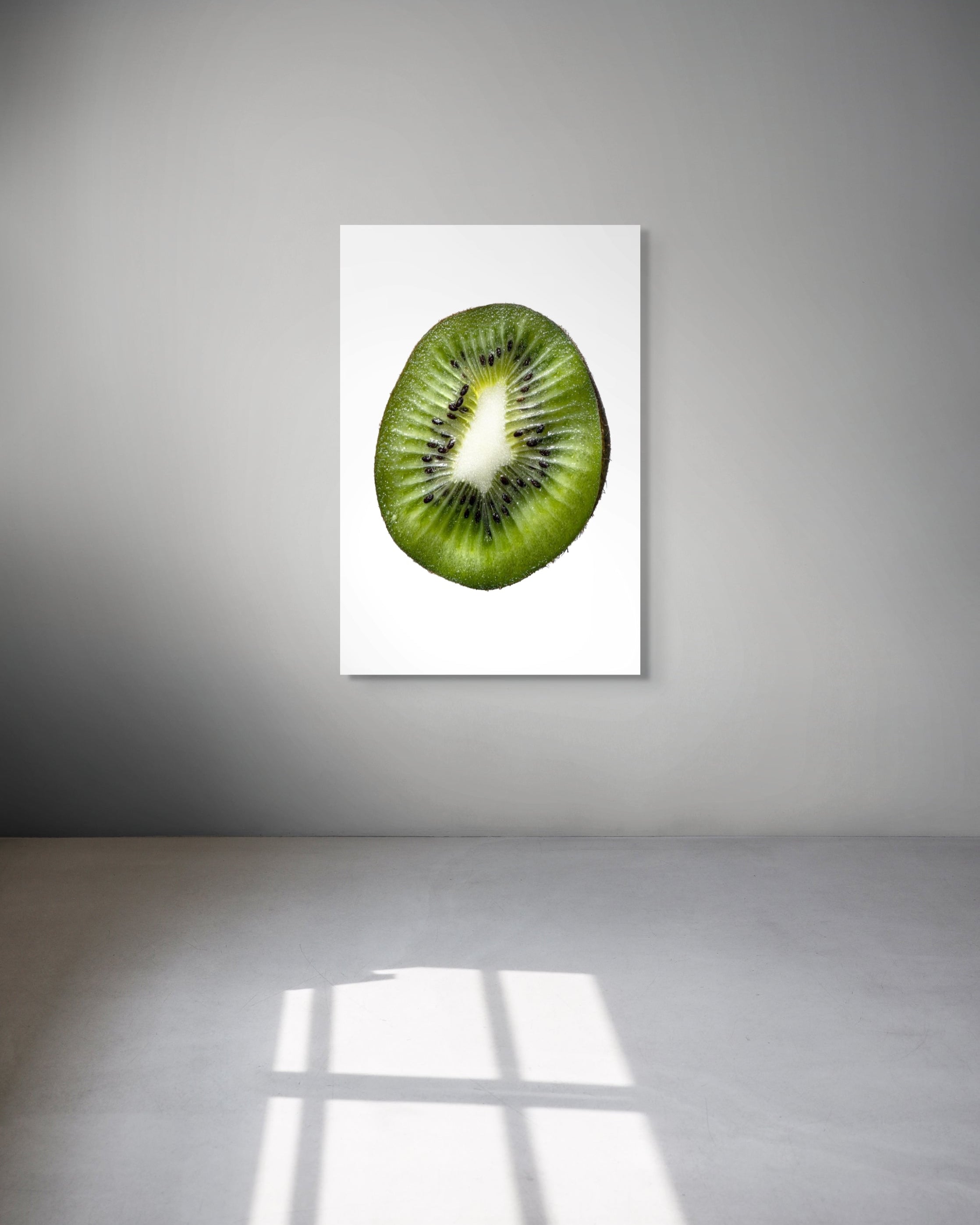 Framed picture of a kiwi fruit on a white wall.