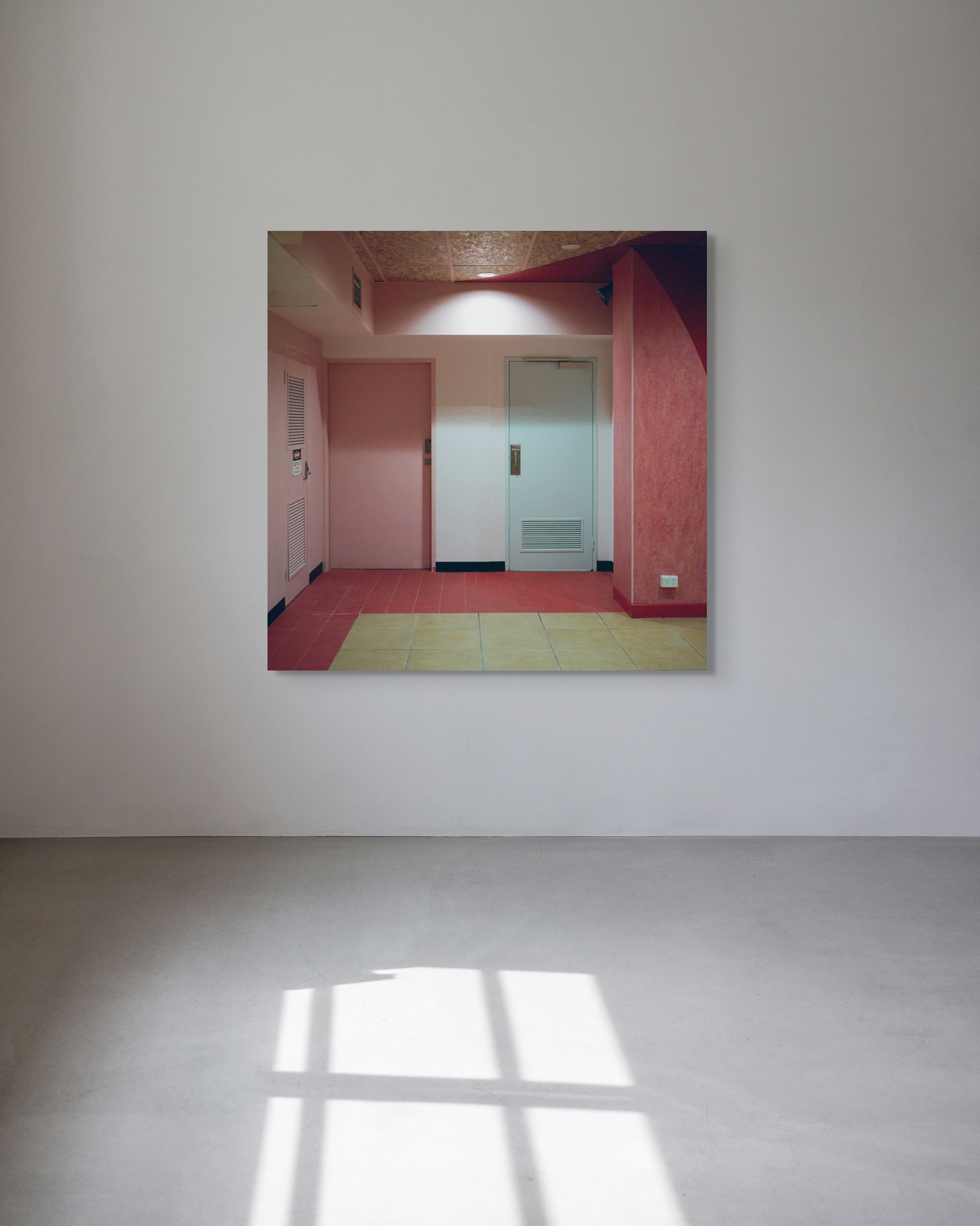 Metal print artwork of a room with pink walls and tiled floor, framed on a white wall.