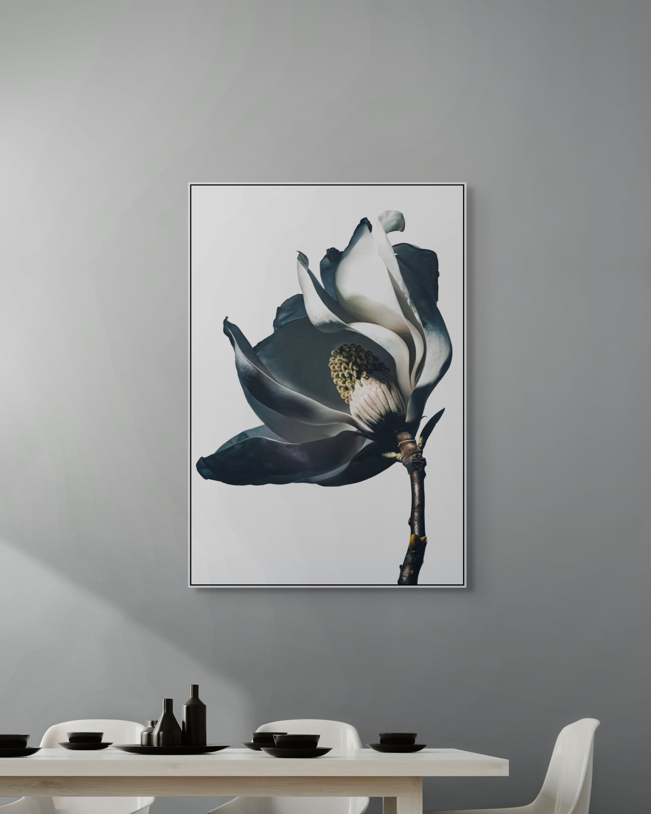 Framed artwork of a flower on a gray wall above a dining table.