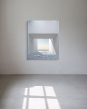 Limited edition metal print on a white wall reflecting a tiled floor