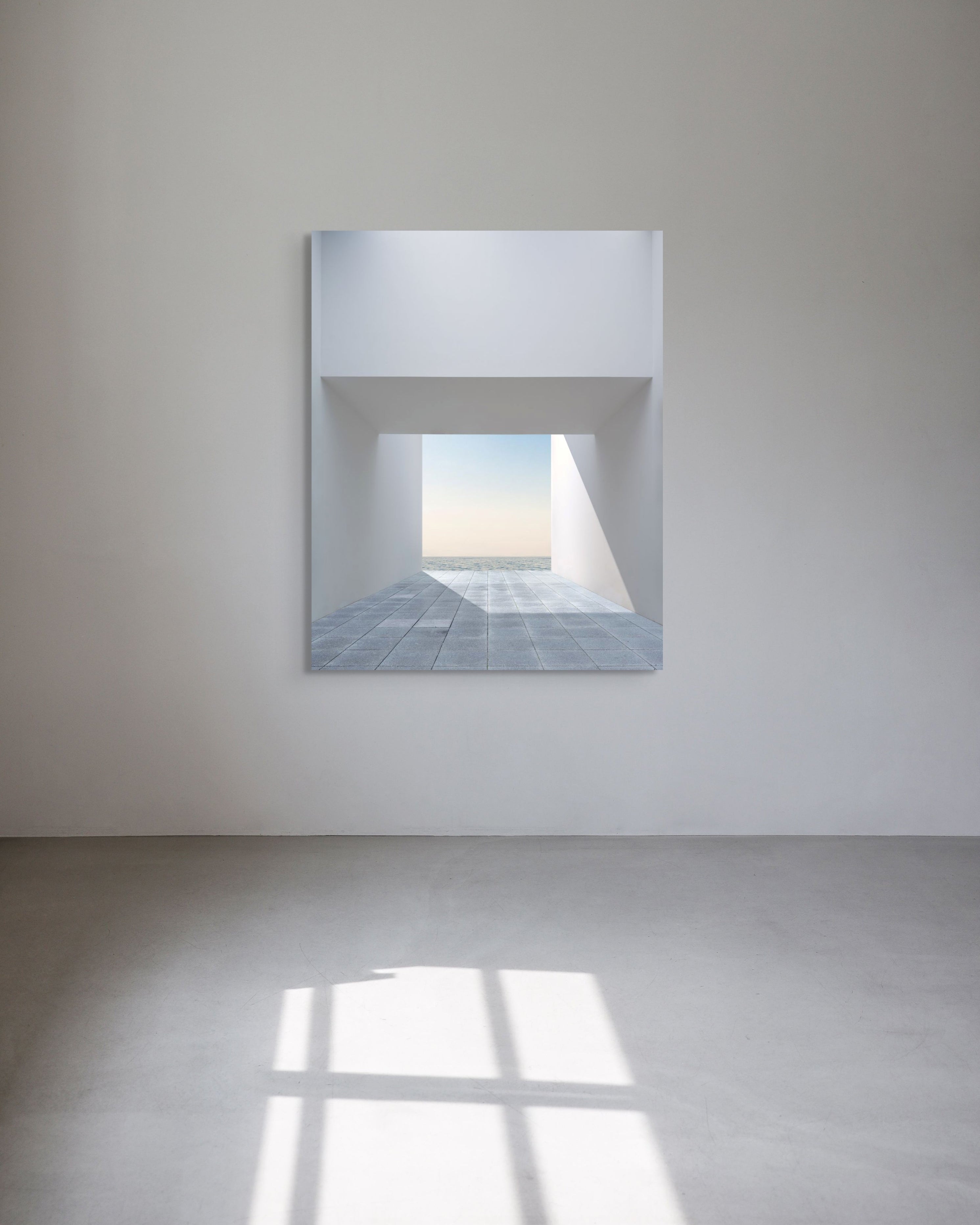 Limited edition metal print on a white wall reflecting a tiled floor