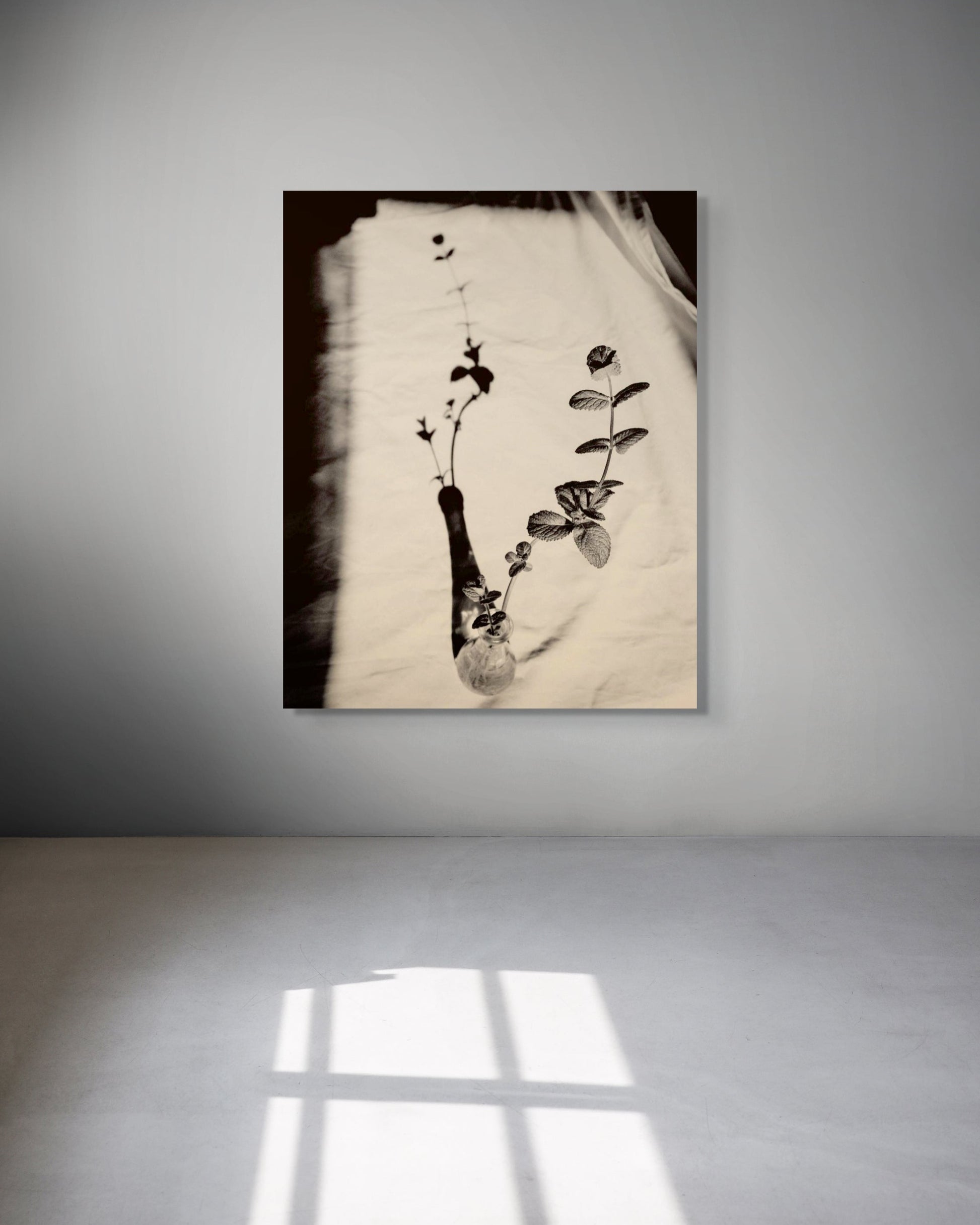 Metal wall art of plants in a vase on a textured surface with a minimal background