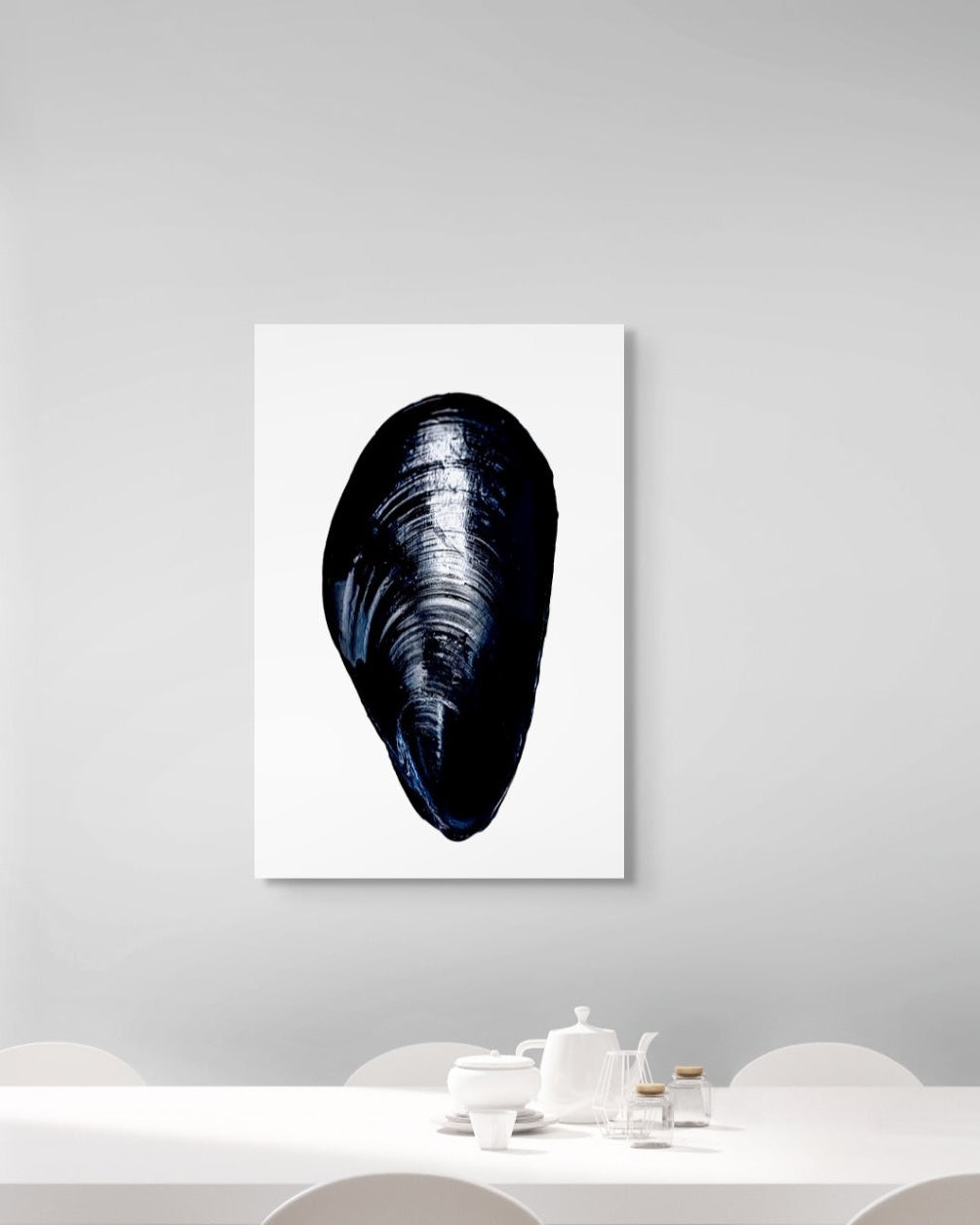 Framed artwork of a mussel shell on a white wall above a dining table.