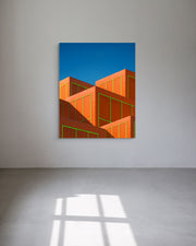 Abstract art piece with geometric shapes on a blue background in a minimalistic room.