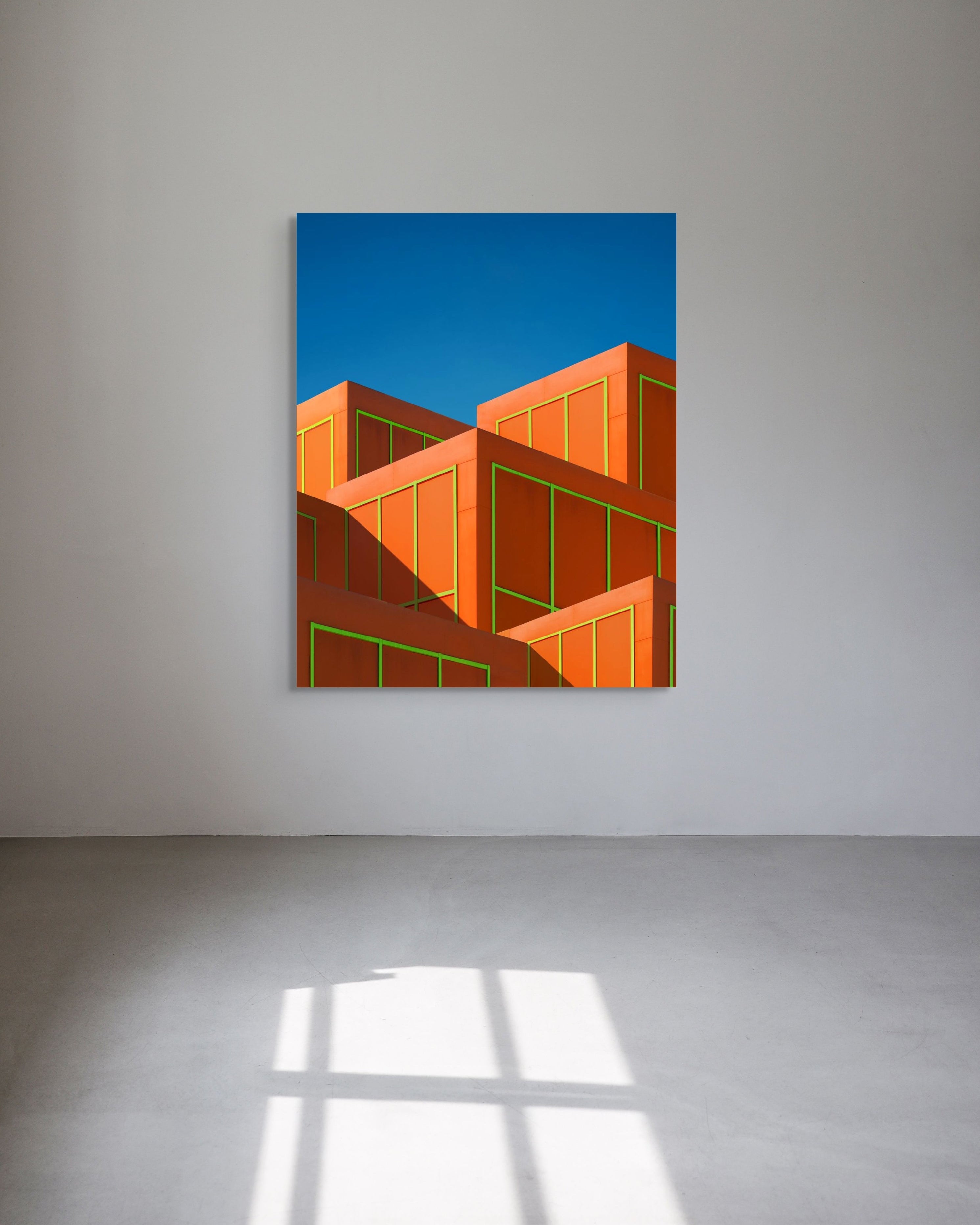 Abstract art piece with geometric shapes on a blue background in a minimalistic room.