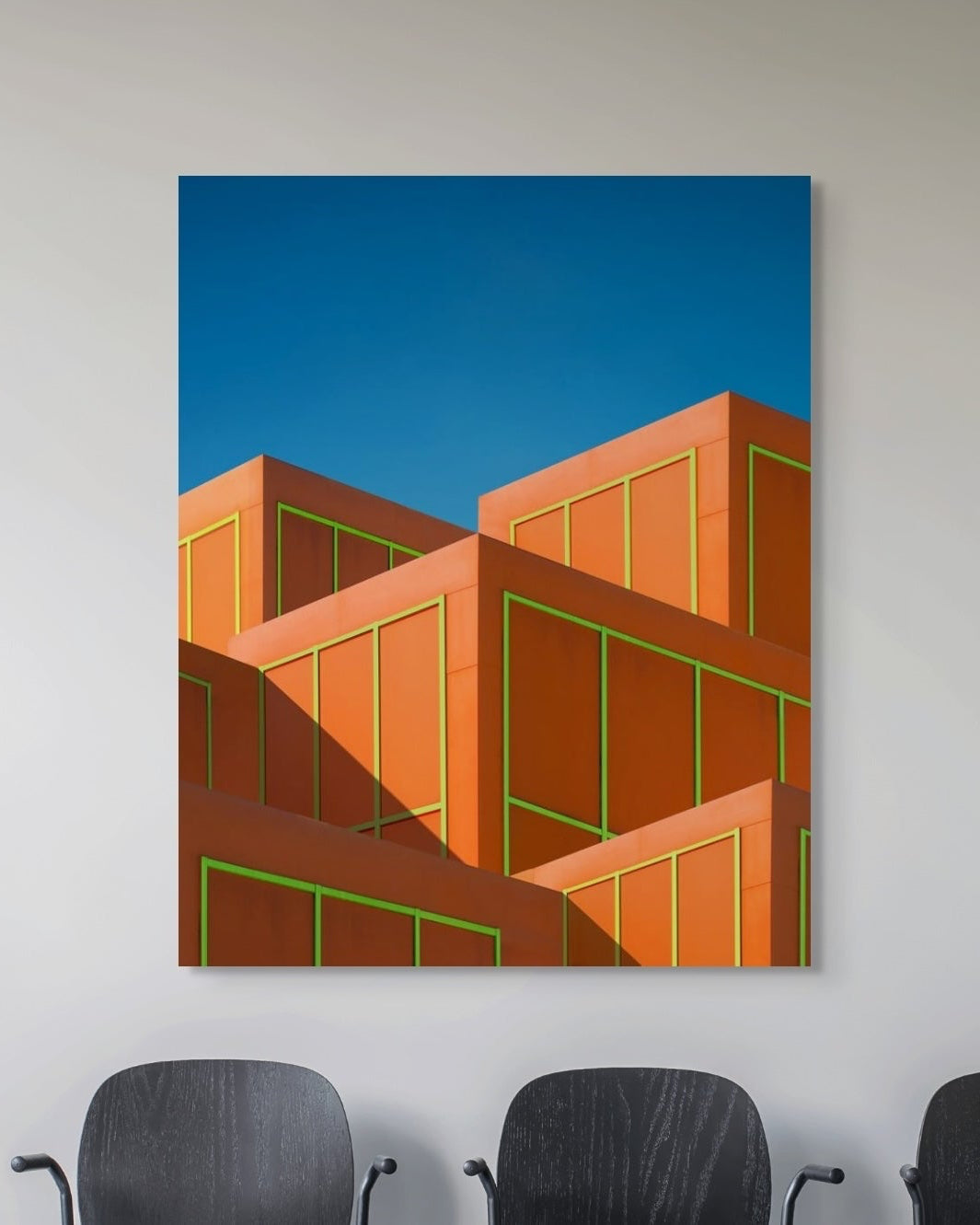 Abstract art print of geometric shapes on a blue background, displayed on a wall.