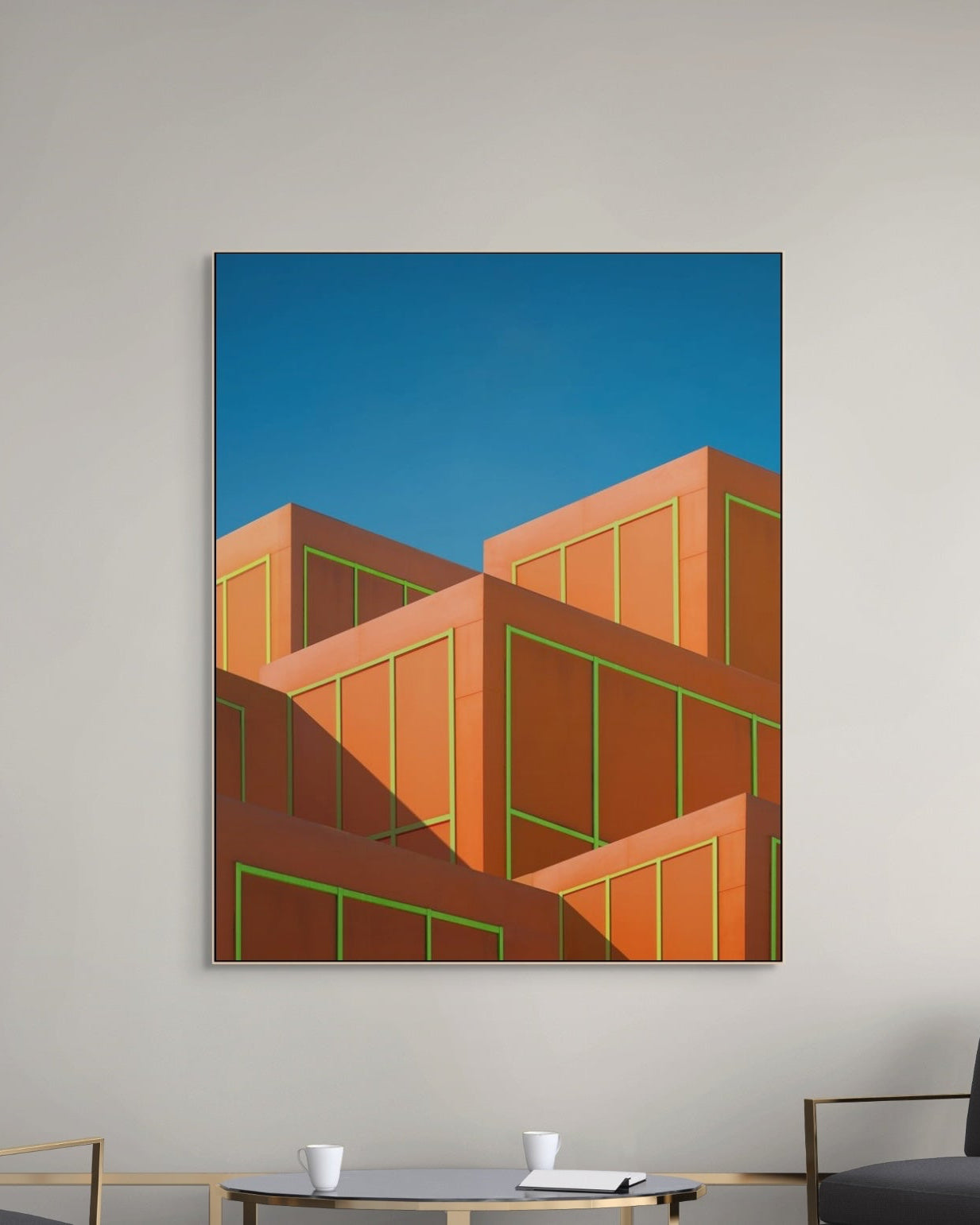Abstract art print of geometric shapes on a wall above a modern living room setup.