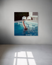 Framed artwork of a person swimming in a pool on a gray wall.