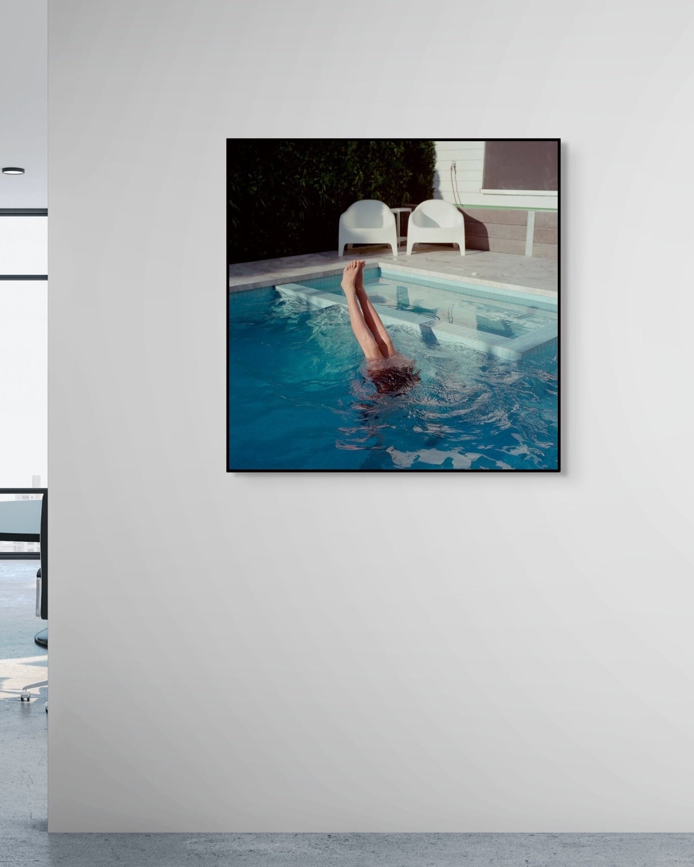 Framed artwork of a person diving into a pool on a white wall.