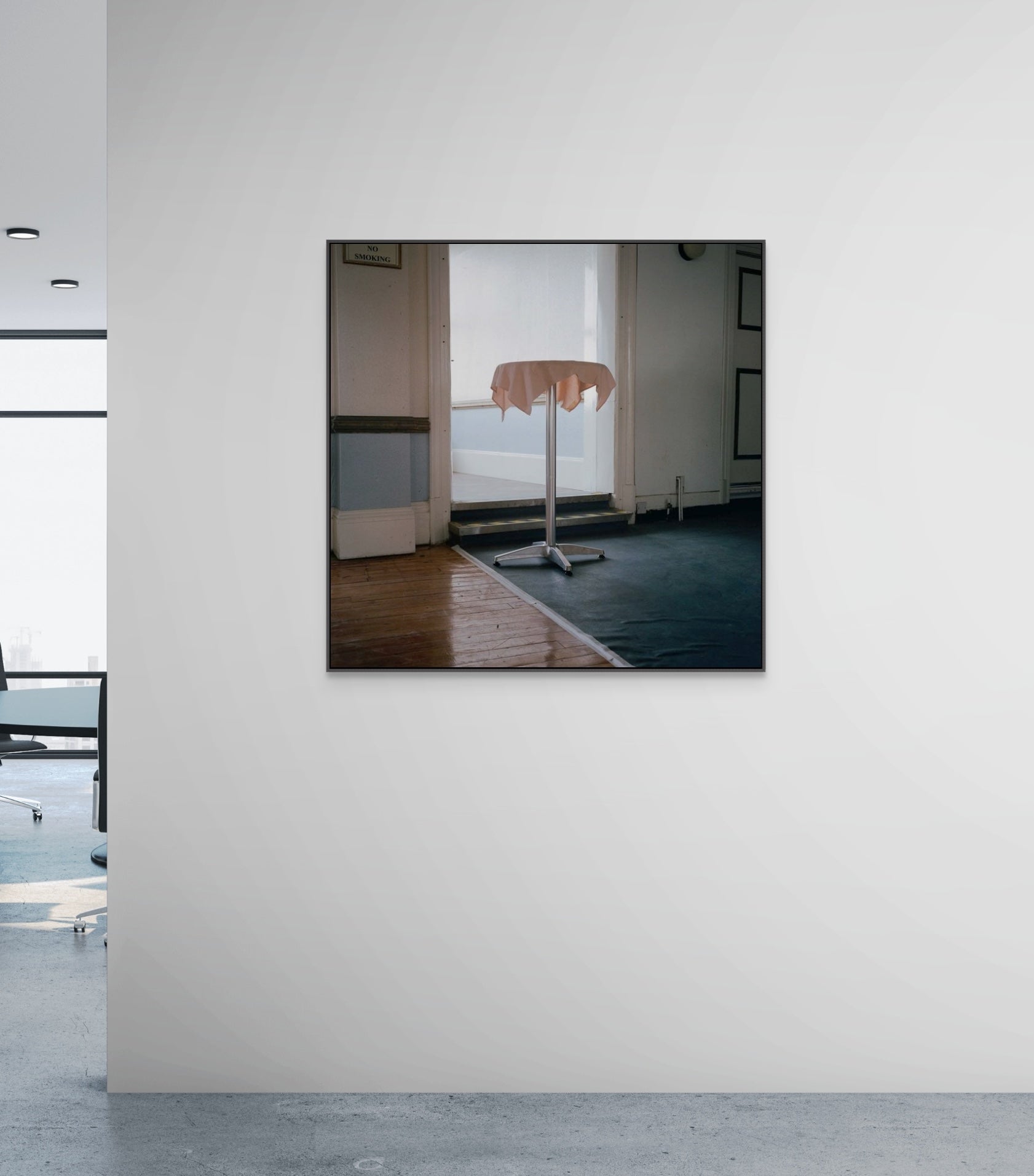 Large print on a white wall reflecting an interior room with a bed and window.