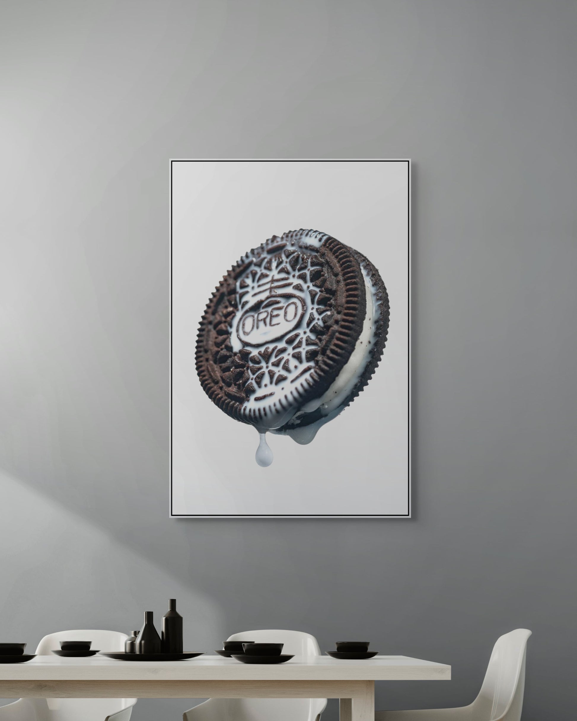 Framed artwork of an Oreo cookie on a gray wall above a dining table.