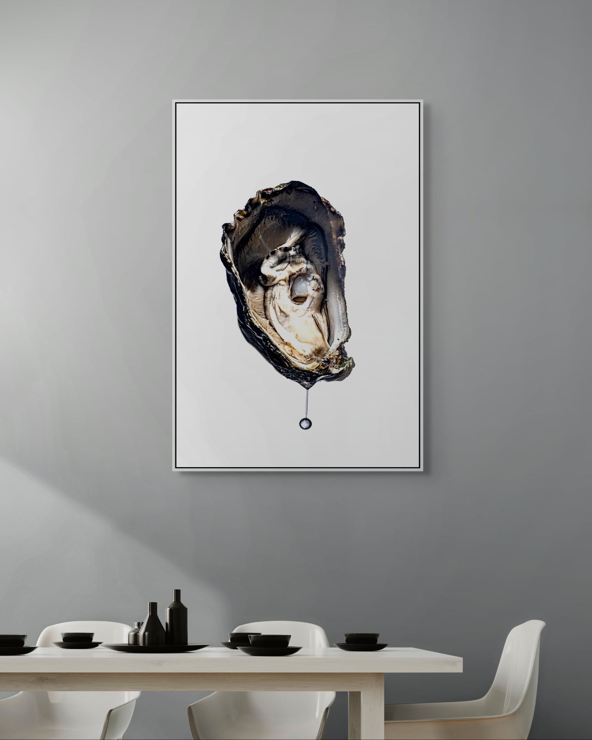 Framed artwork of an oyster on a gray wall above a dining table.