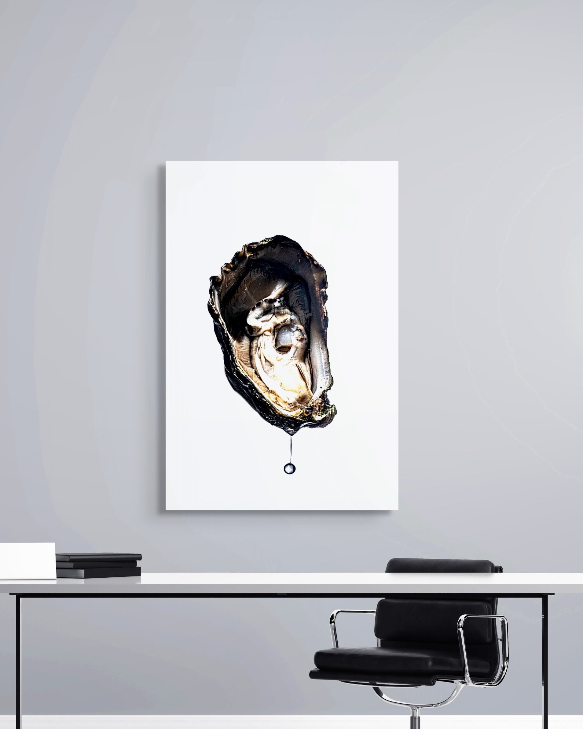 Framed artwork of an oyster on a wall above a desk.