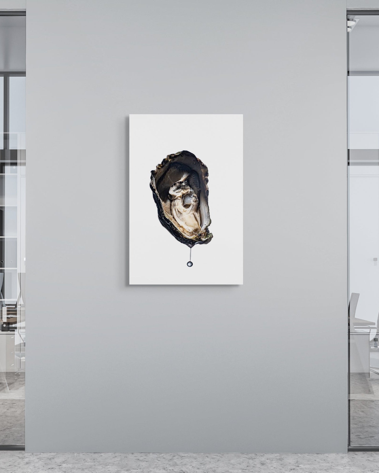 Modern office interior with a framed artwork of an oyster on a gray wall.
