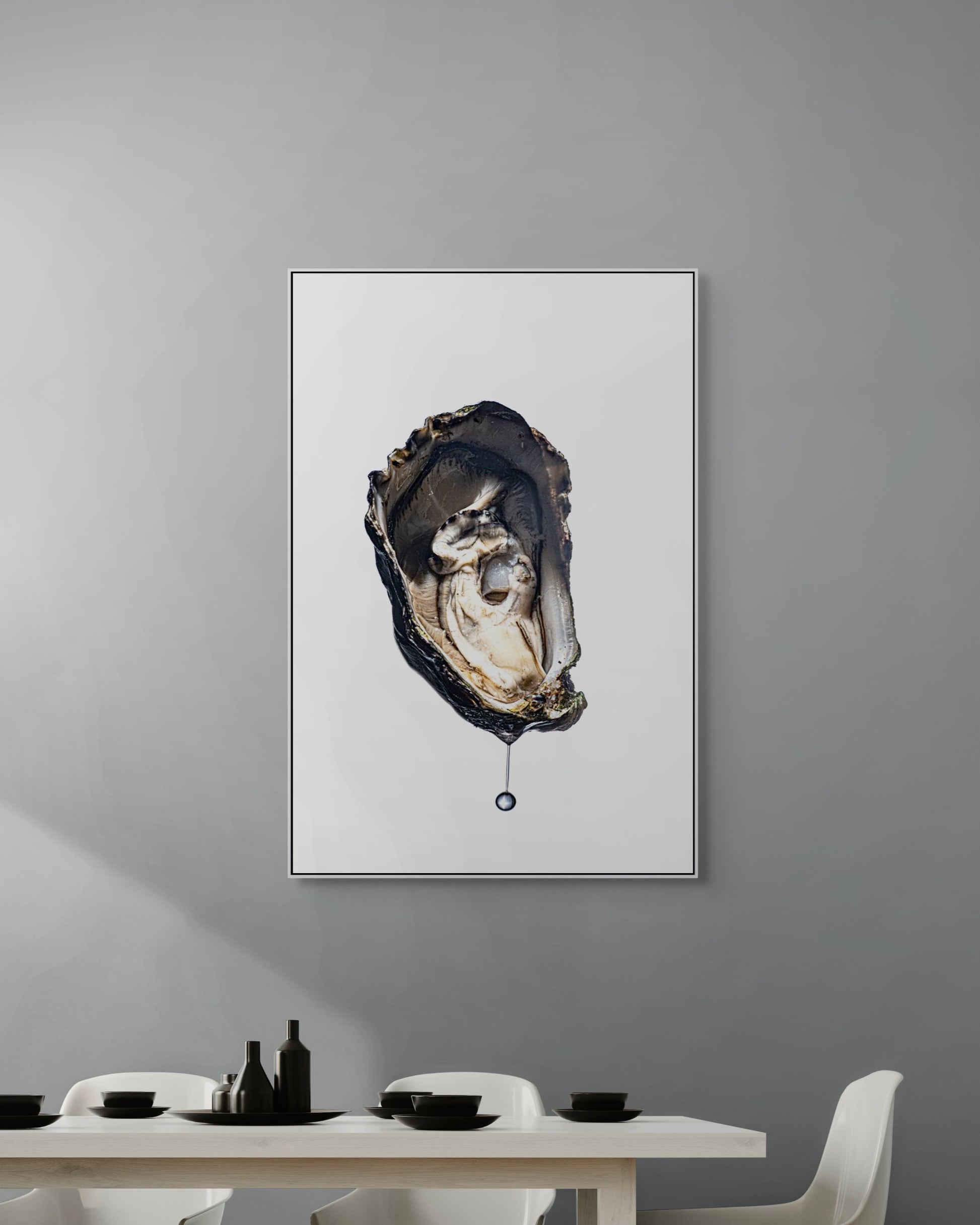Framed artwork of an oyster on a gray wall above a dining table.