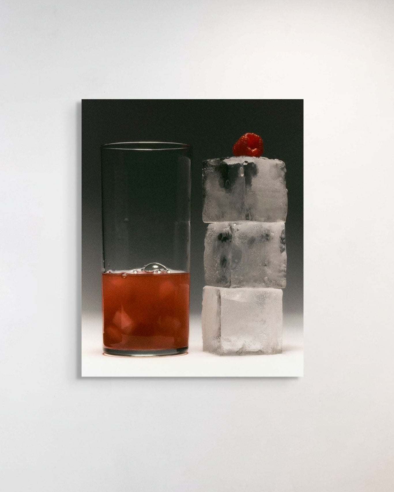 Cocktail with red liquid in a glass and a stacked ice cubes on a white background
