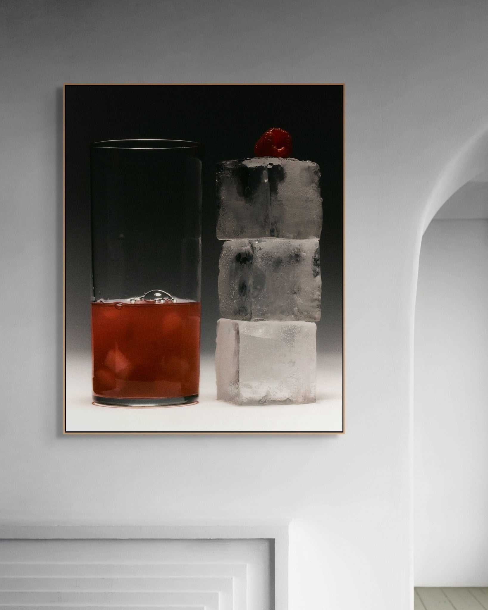 Framed artwork of a cocktail with ice cubes on a gray wall.