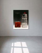 Metal print of two glasses, one with a red drink and ice cubes, the other with a clear liquid and ice cubes, on a black background.