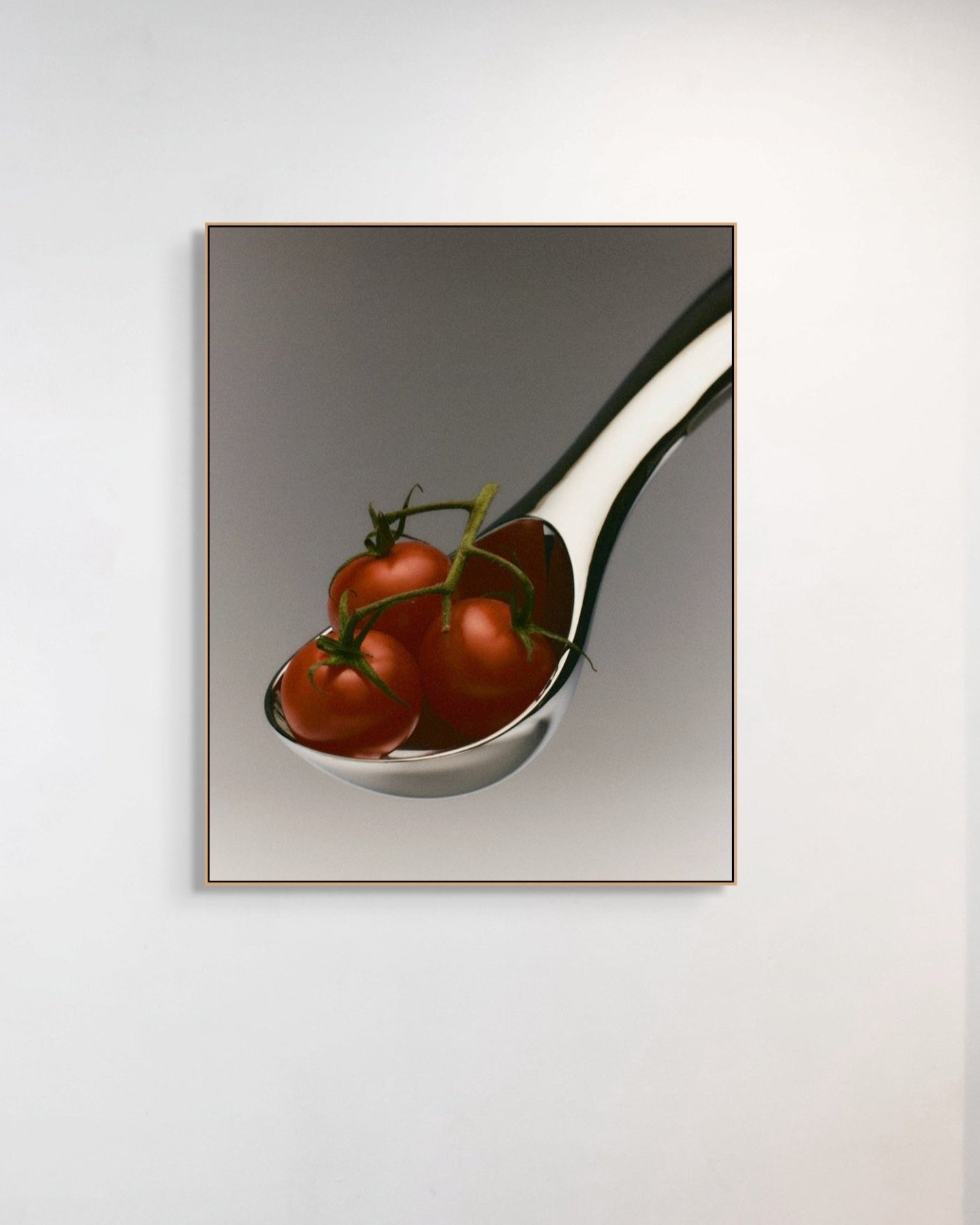 Spoon with cherry tomatoes on a reflective surface