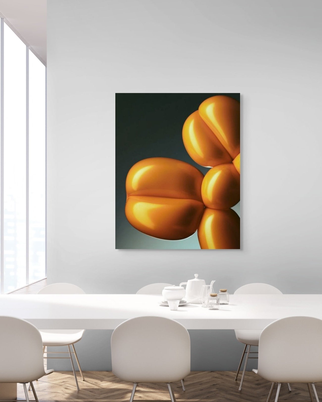 Modern interior with a table and chairs, featuring a large abstract metal print of a gold balloon sculpture on the wall.