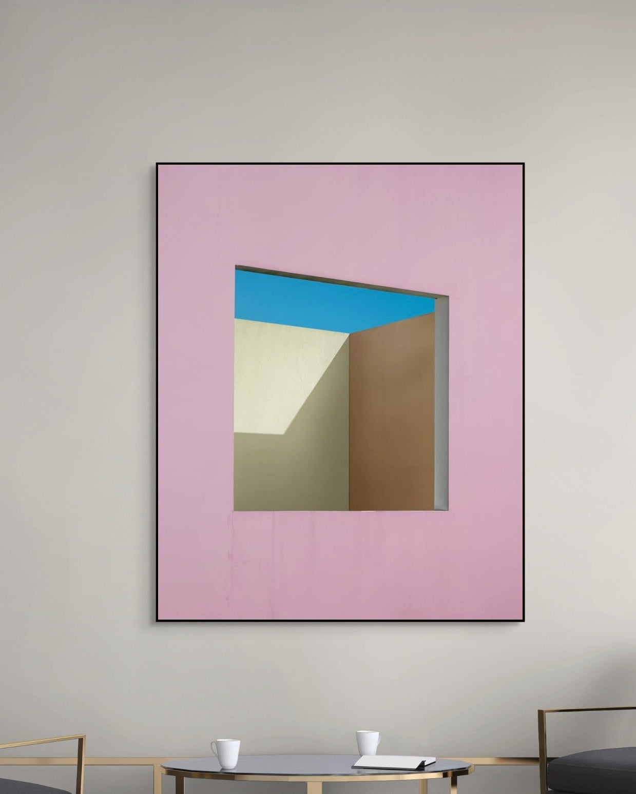 Framed abstract artwork with geometric shapes on a pink background, displayed in a room.