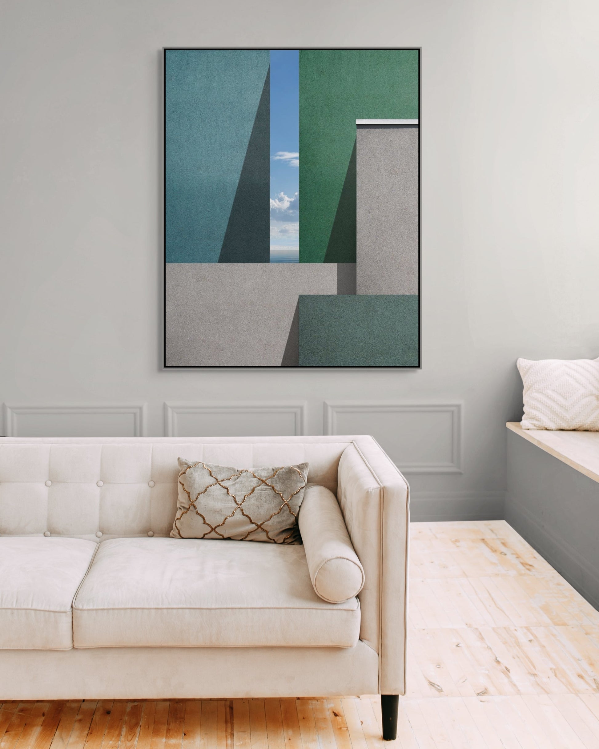 Architectural wall art above a white sofa in a modern living room with light gray walls.