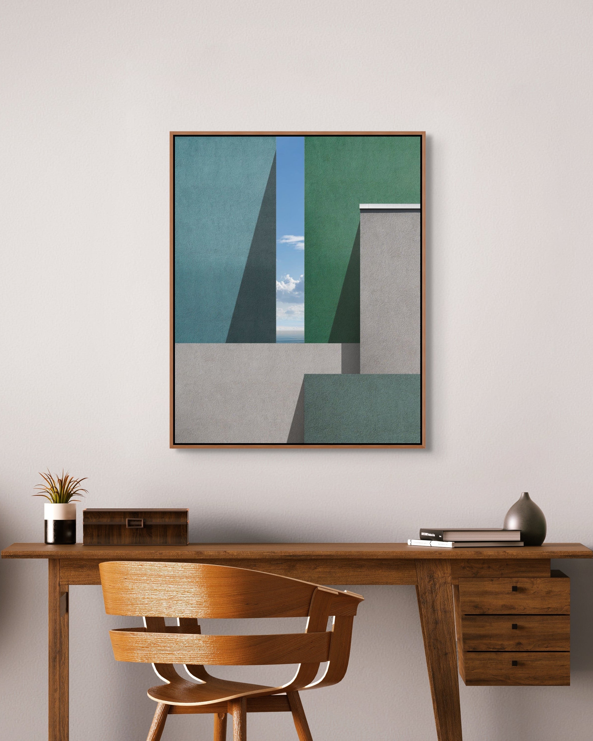 Architectural fine art photograph by Marc Fischer displayed above a wooden desk in a contemporary workspace with neutral walls and warm tones.