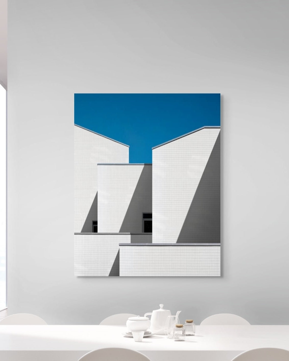 Abstract art piece with geometric shapes on a white wall in a modern interior setting.