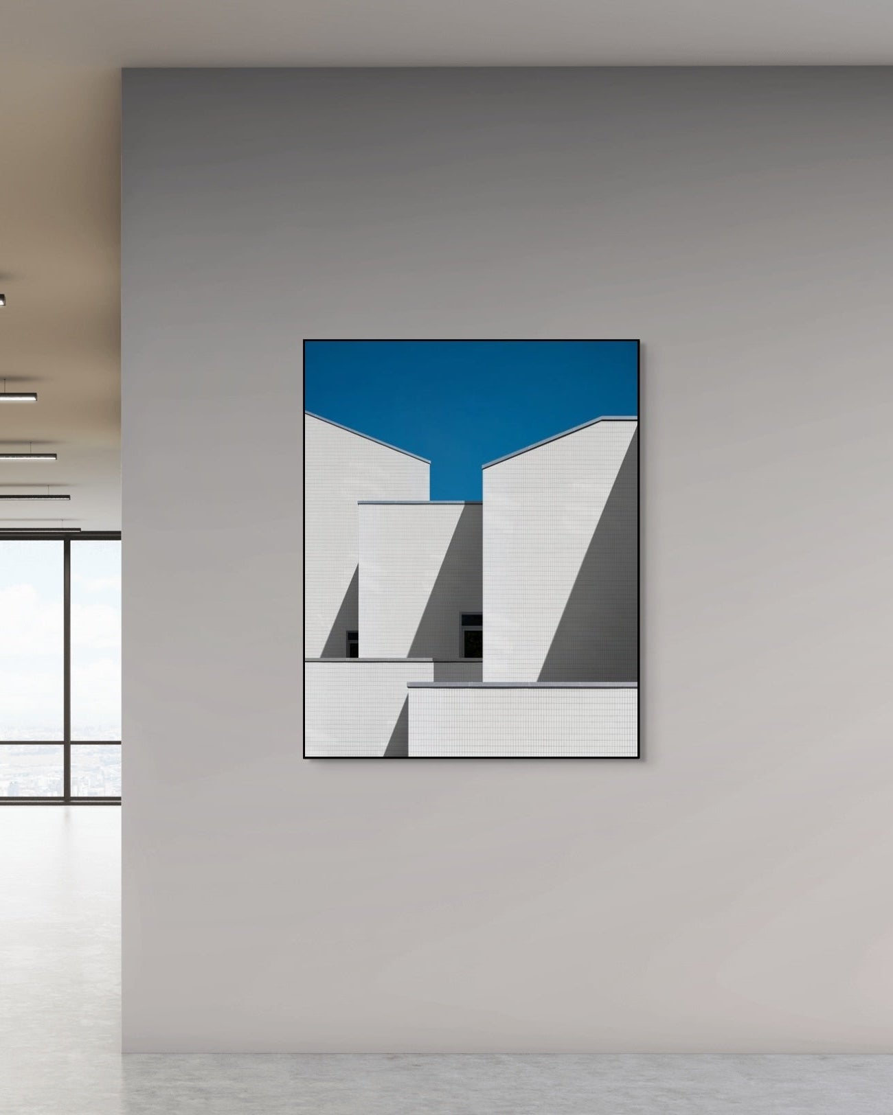 Abstract art piece with blue and white geometric design on a gray wall.