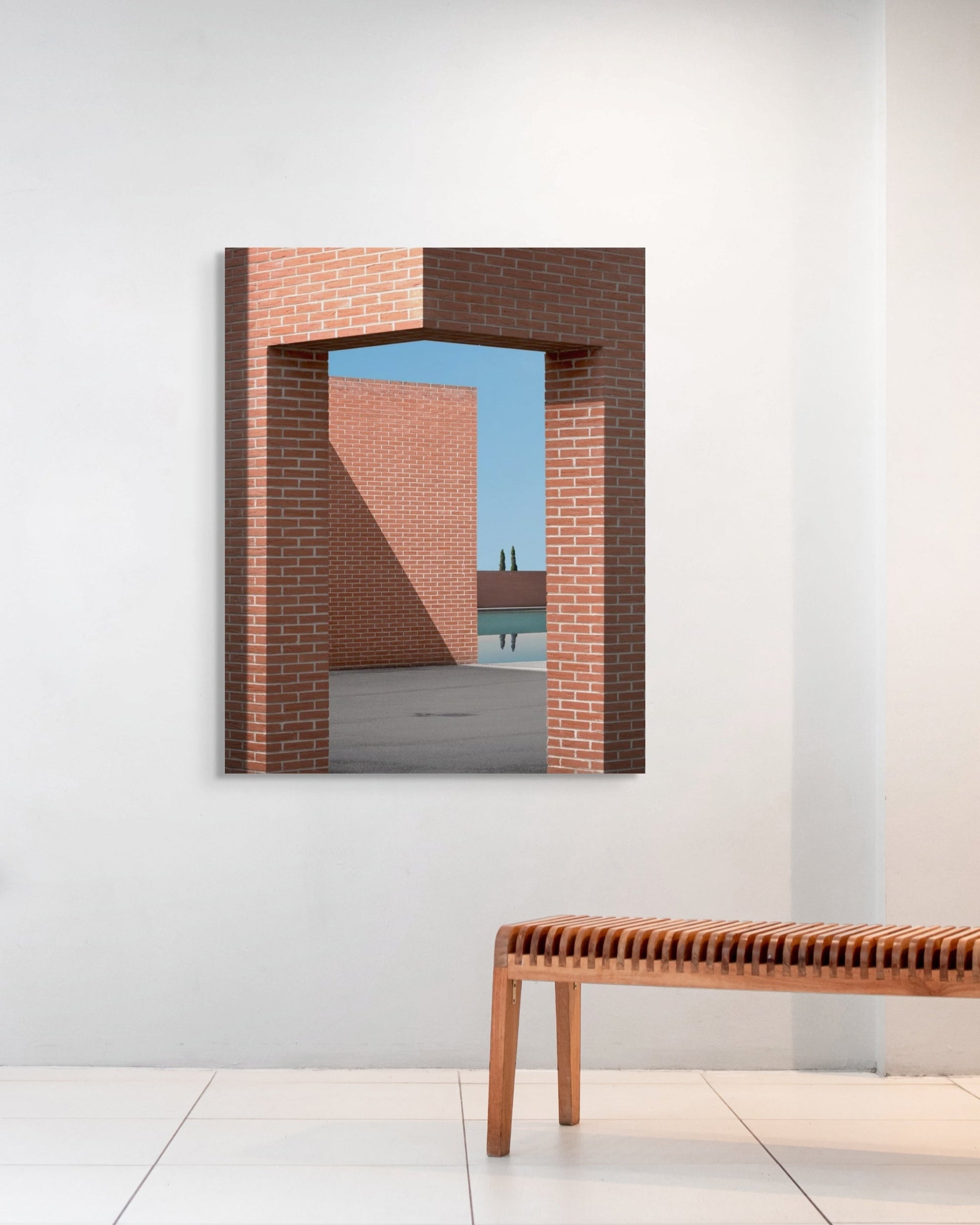 Framed abstract artwork on a wall with a wooden bench below