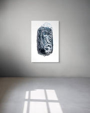 Abstract art piece on a white wall with a gray floor.