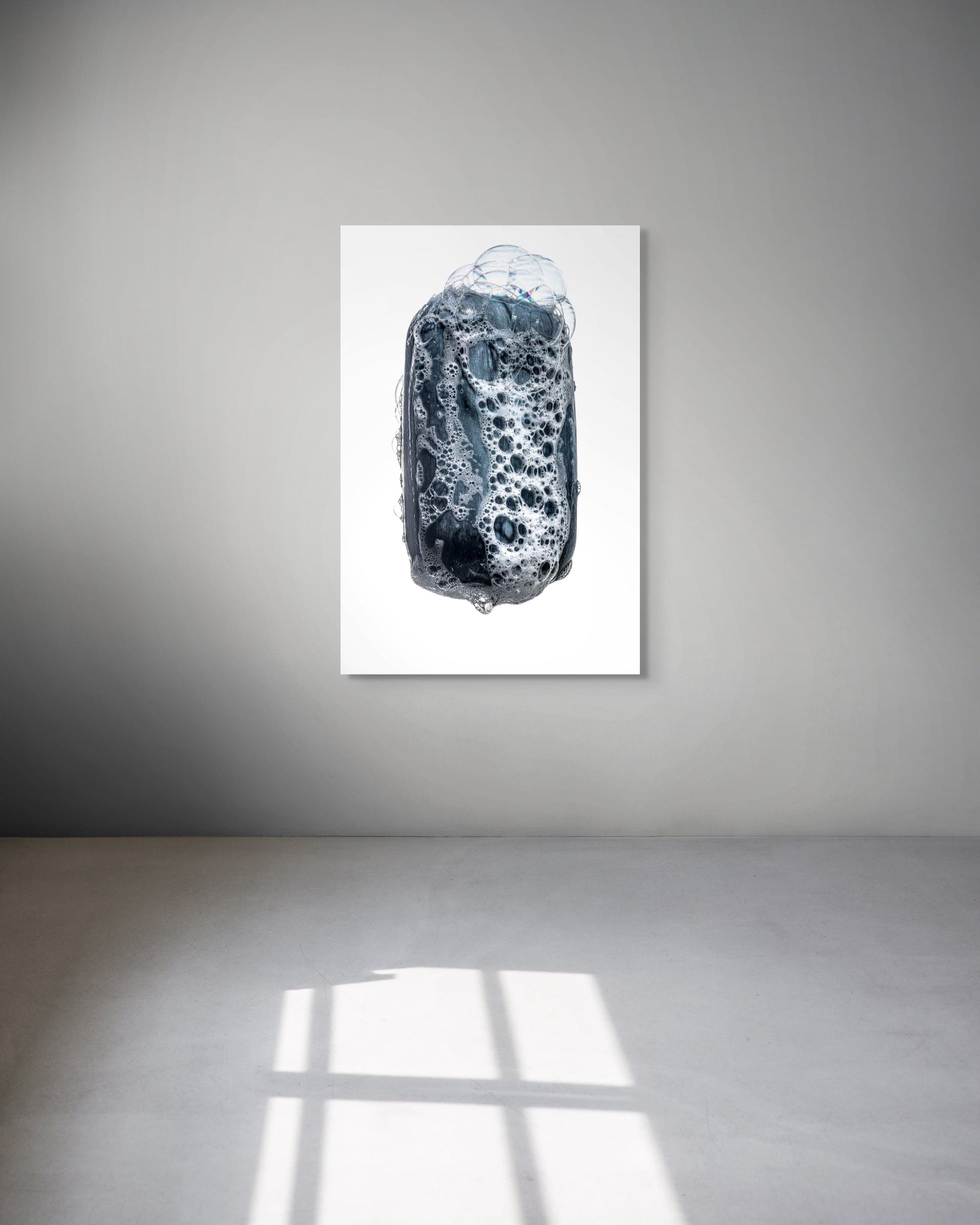 Abstract art piece on a white wall with a gray floor.