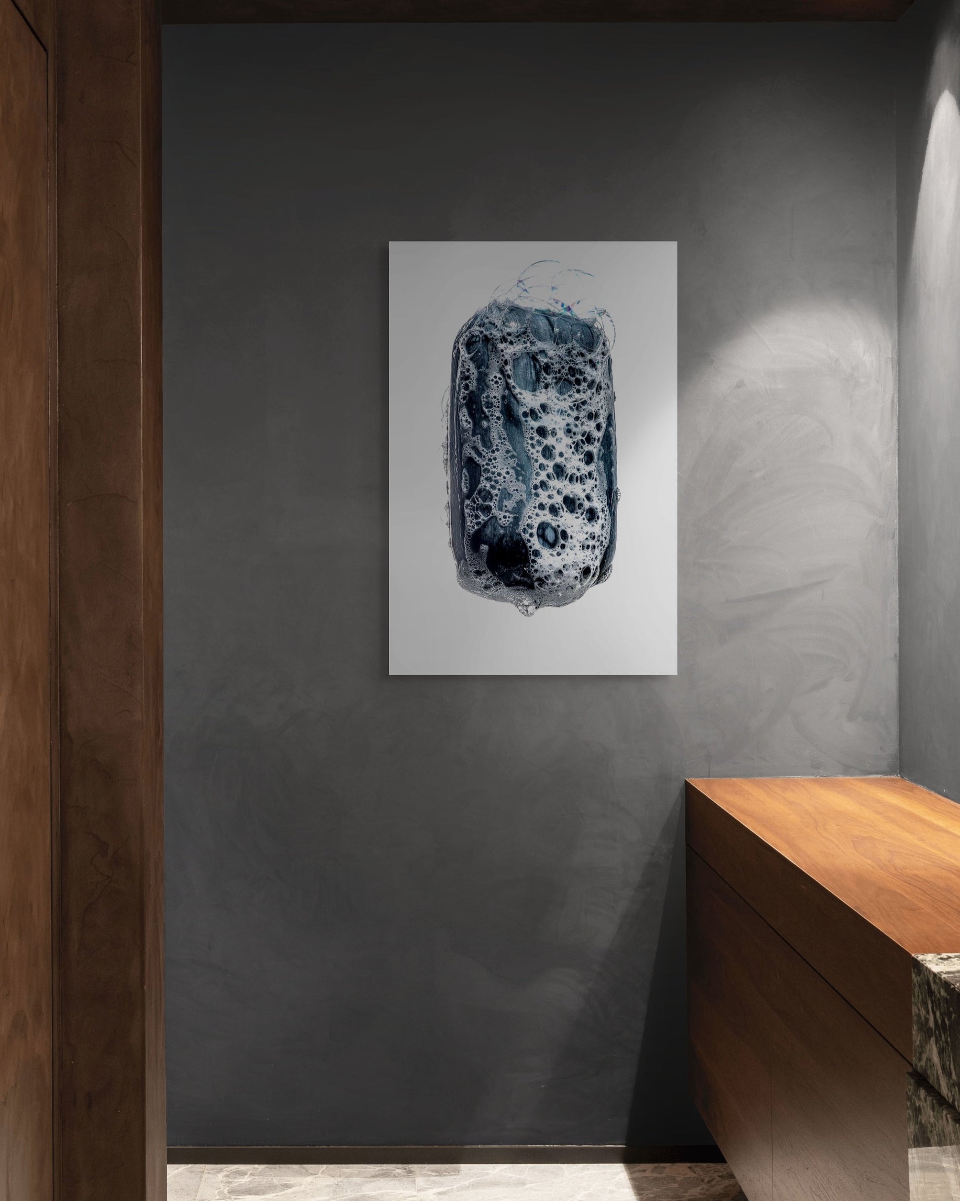 Abstract art piece on a gray wall with wooden furniture.