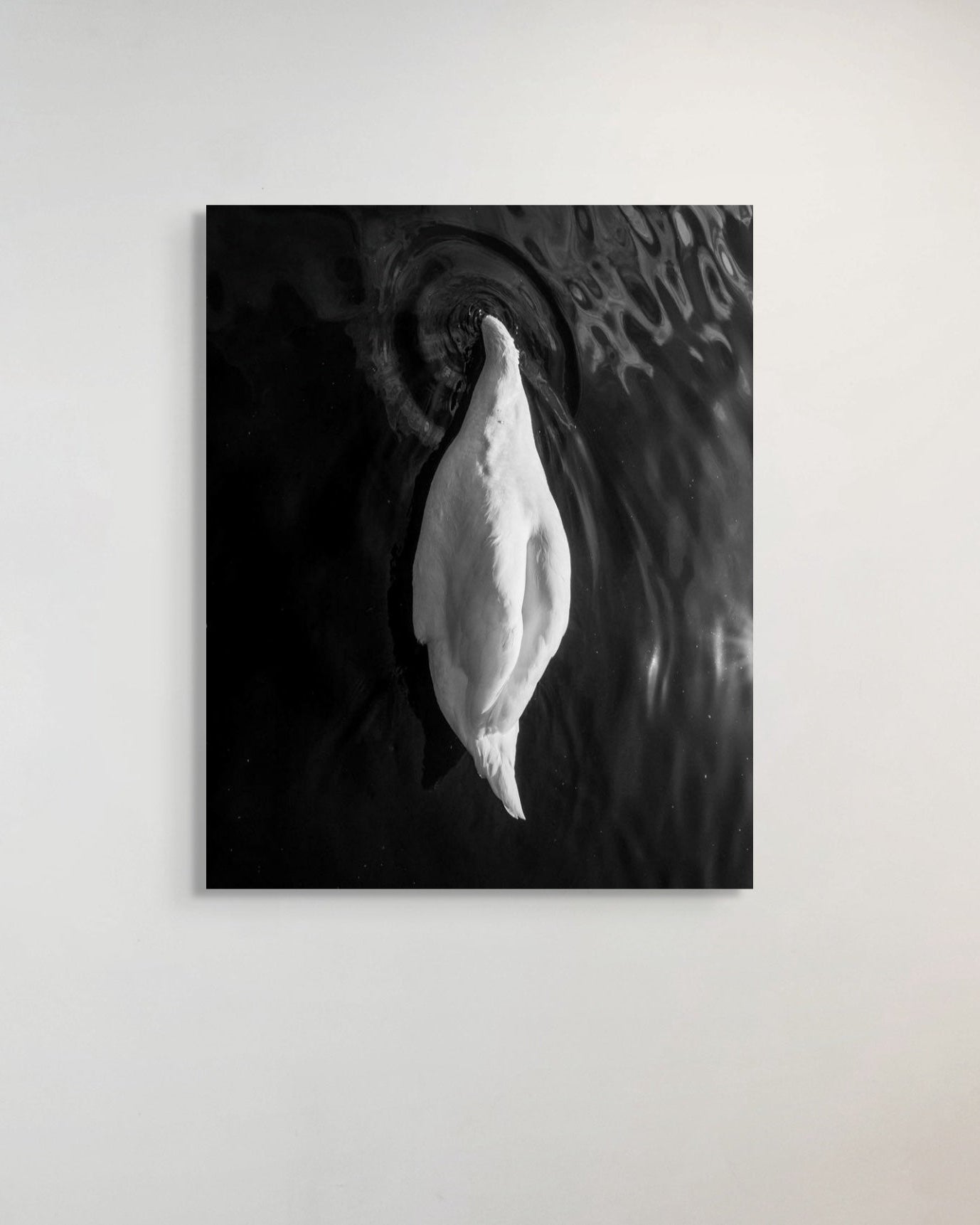 Black and white abstract art piece on a plain wall