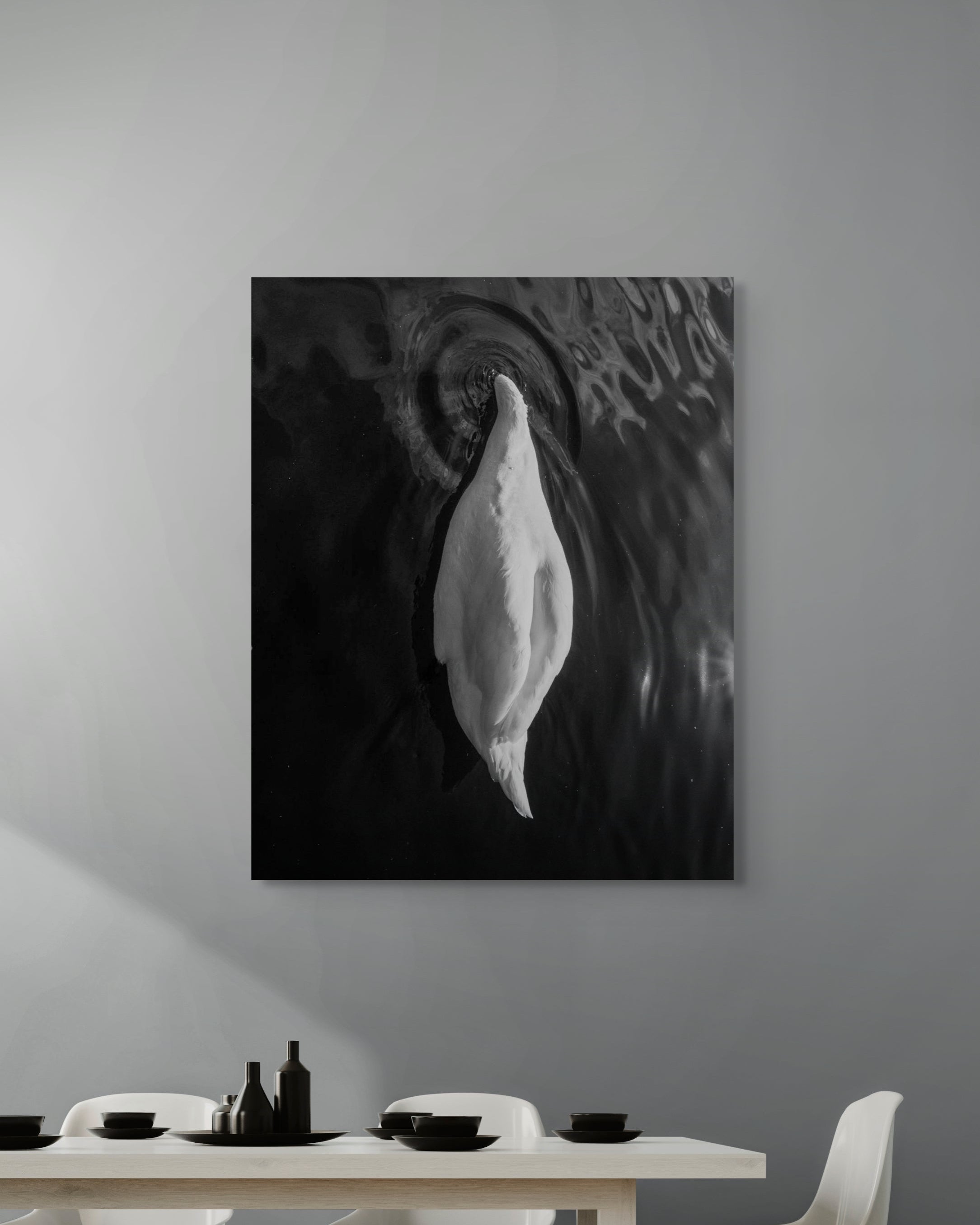 Abstract black and white painting on a gray wall above a dining table.