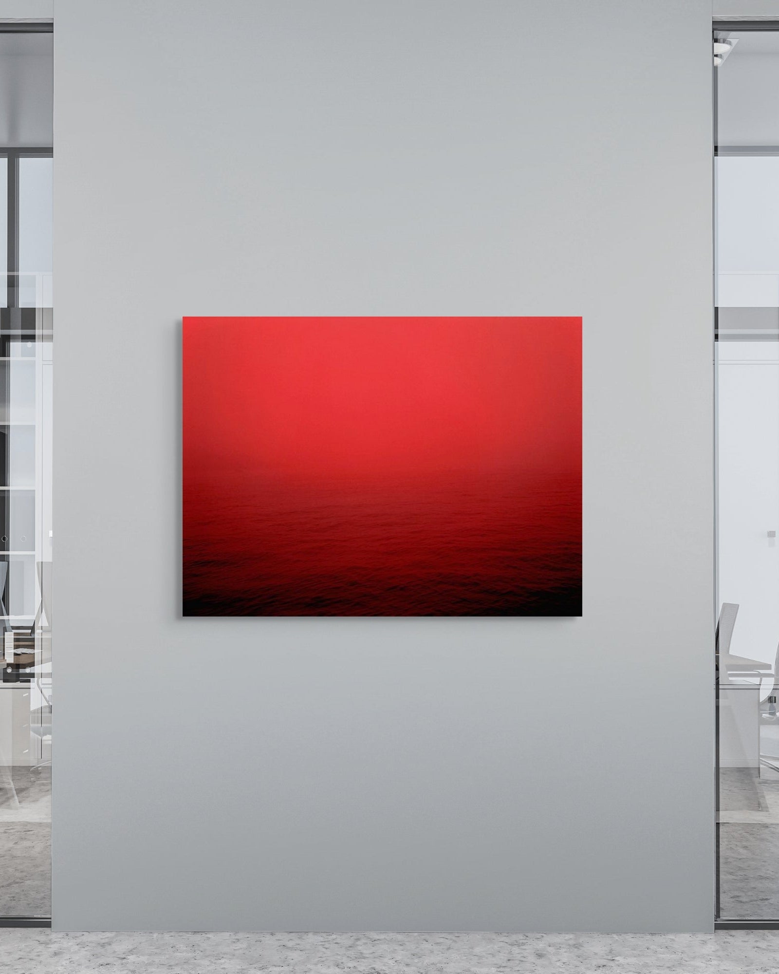 Red abstract metal print on a wall in an office setting