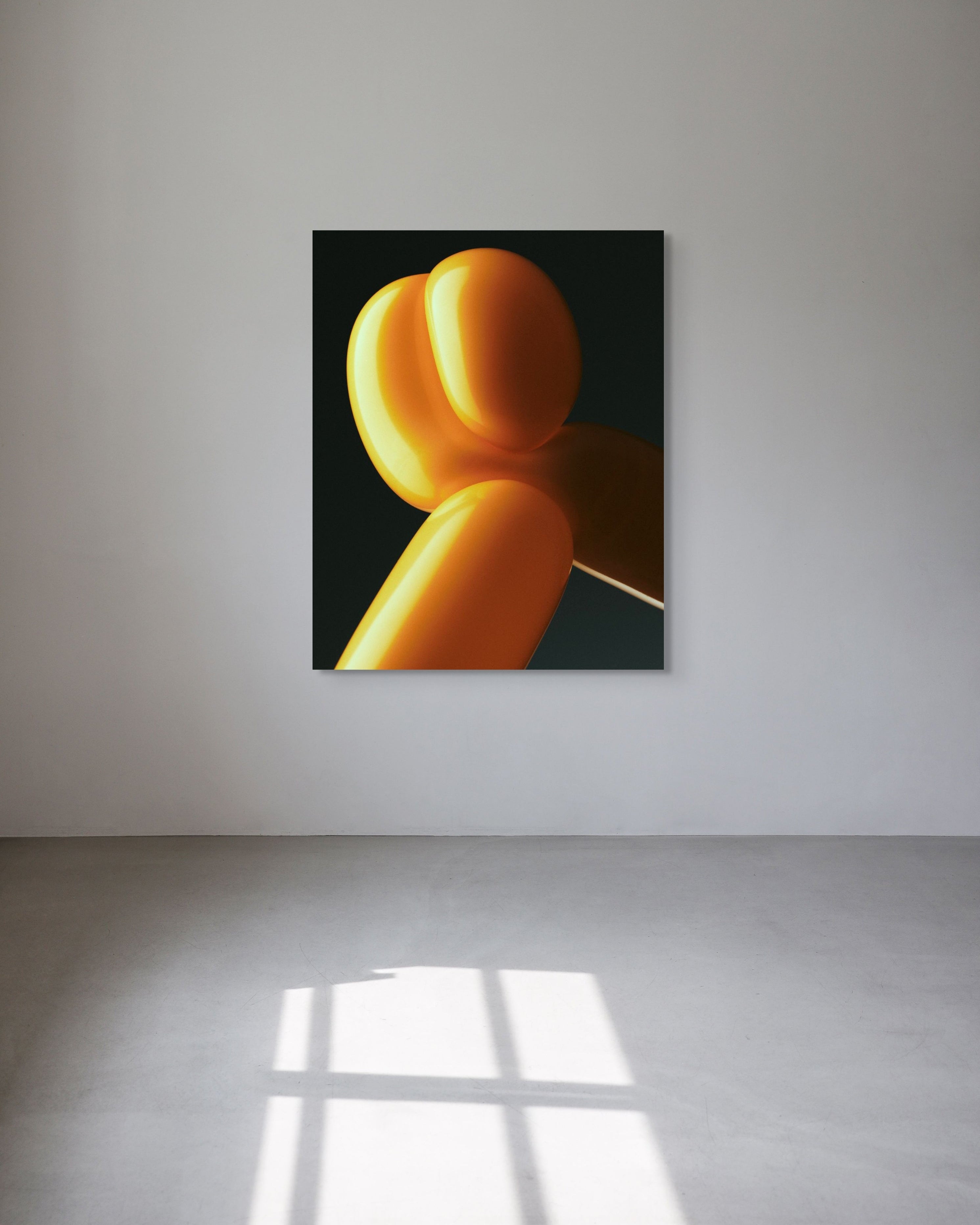 Abstract art piece with orange shapes on a black background in a minimalistic room.