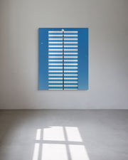 Blue and white striped artwork on a white wall