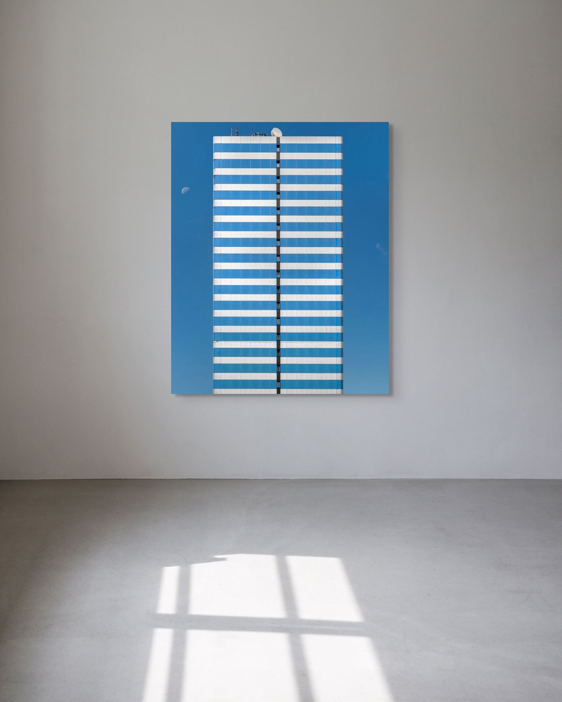 Blue and white striped artwork on a gray wall