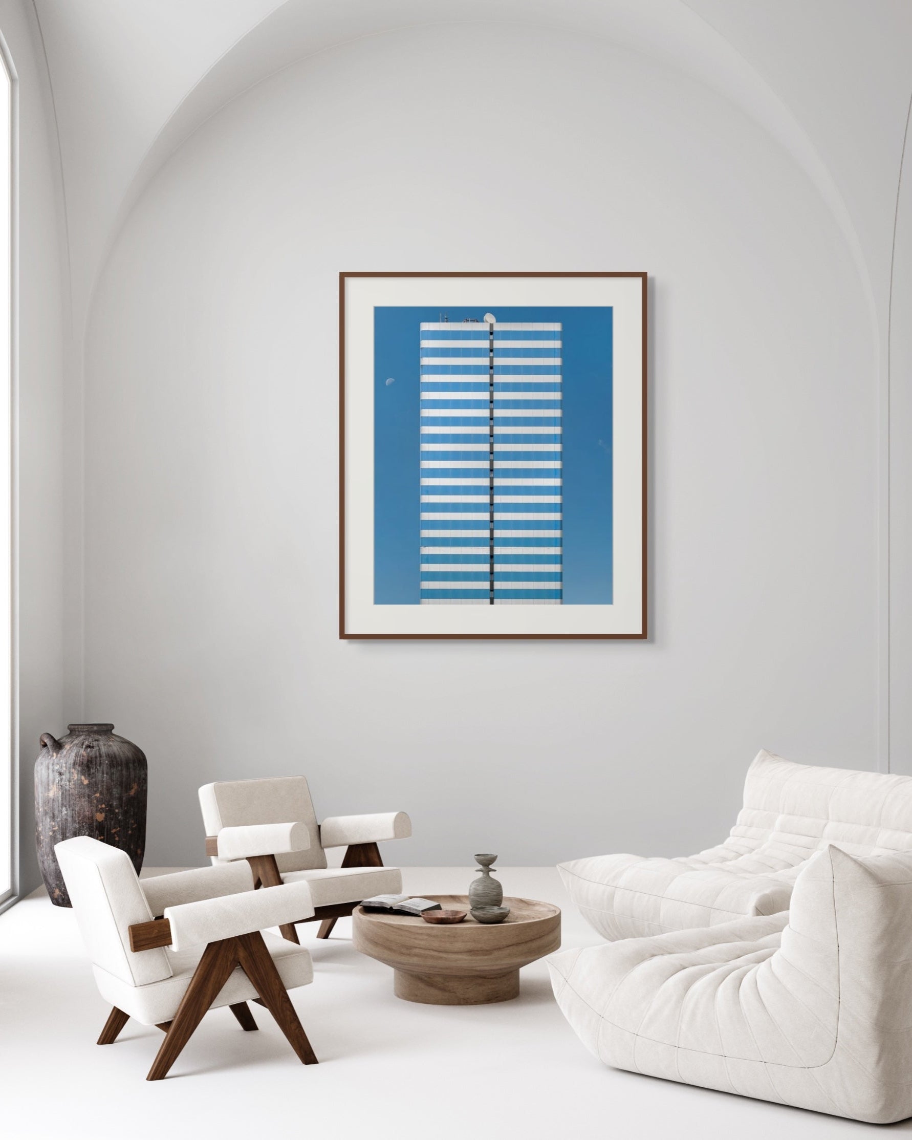 Modern living room with white furniture and a blue framed artwork on the wall.